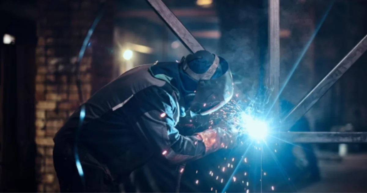 Welder working on a metal structure with sparks flying.