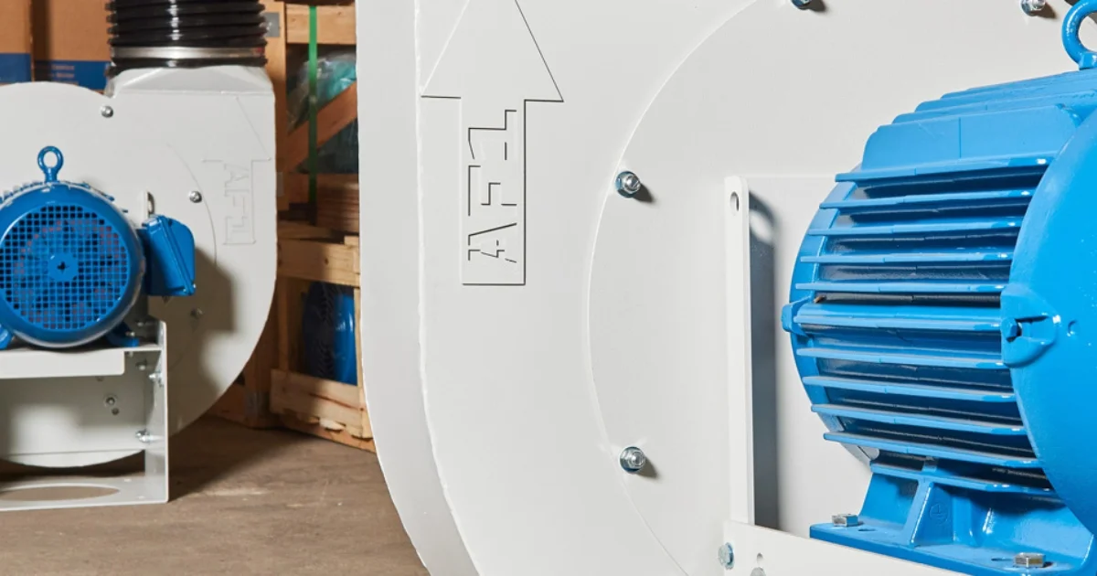 Close-up of industrial blowers with blue motors in a workshop.
