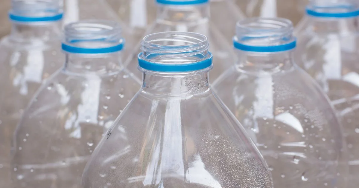 Close-up view of clear plastic water bottles arranged in rows.