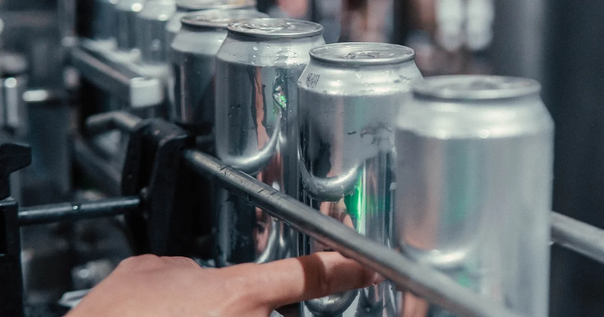 Close-up view of aluminum beverage cans being guided through a manufacturing conveyor system.
