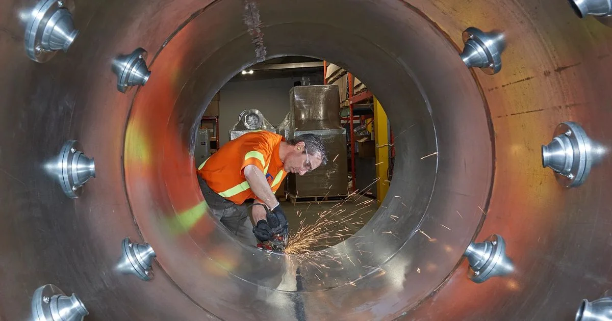 Technician grinding inside industrial air dry system installation